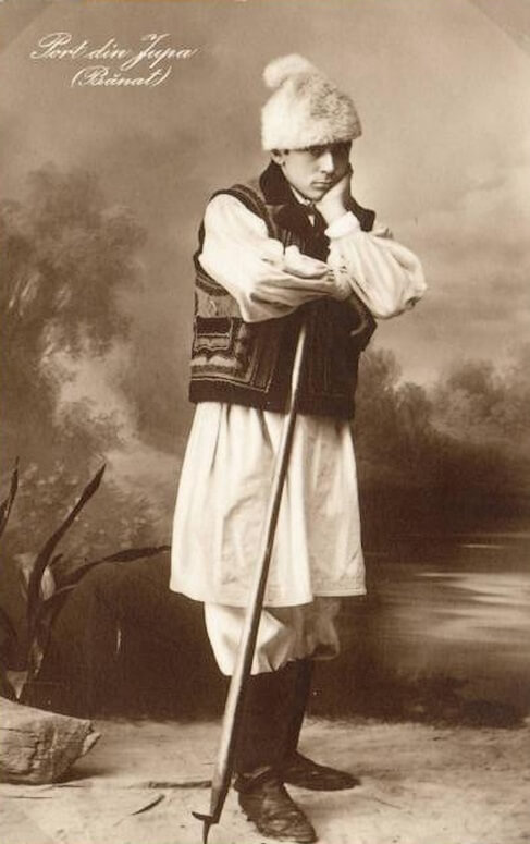 Romanian traditional dress worn by man from Banat region which is today in Romania and Serbia. His clothes are black and white. Starting from white fur hat, black blaizer , white long pants and black footwear. Picture is black and white format.