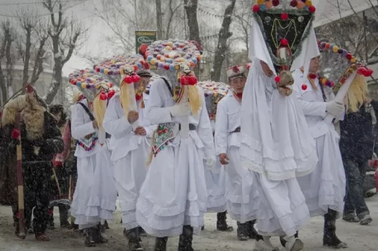Pre-hrišćanski običaji u Rumuna (Vlaha) - Ispraćajna povorka ljudi u belom koji nose razne ukrase u bojama
